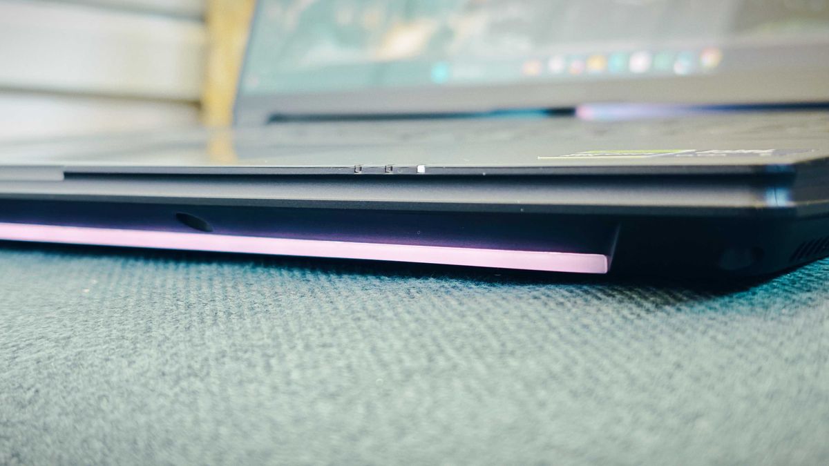 A Gigabyte Aorus Master 16 laptop on a green sofa