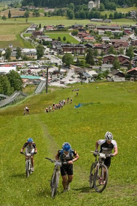 Riders walk up a steep ski slope during stage 3 of the Bike Four Peaks