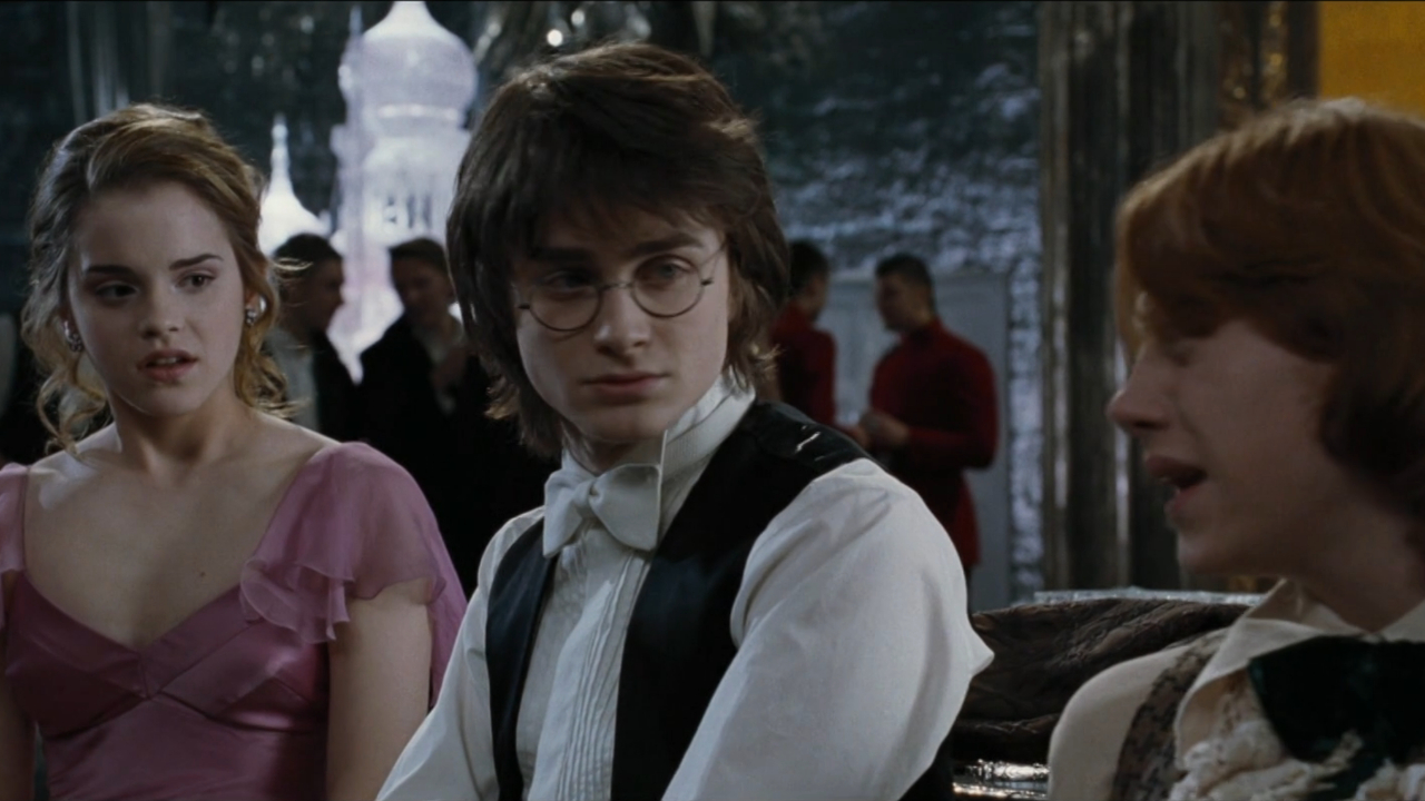 Daniel Radcliffe se sienta incómodo entre Emma Watson y Rupert Grint en el baile de Navidad en Harry Potter y el cáliz de fuego.