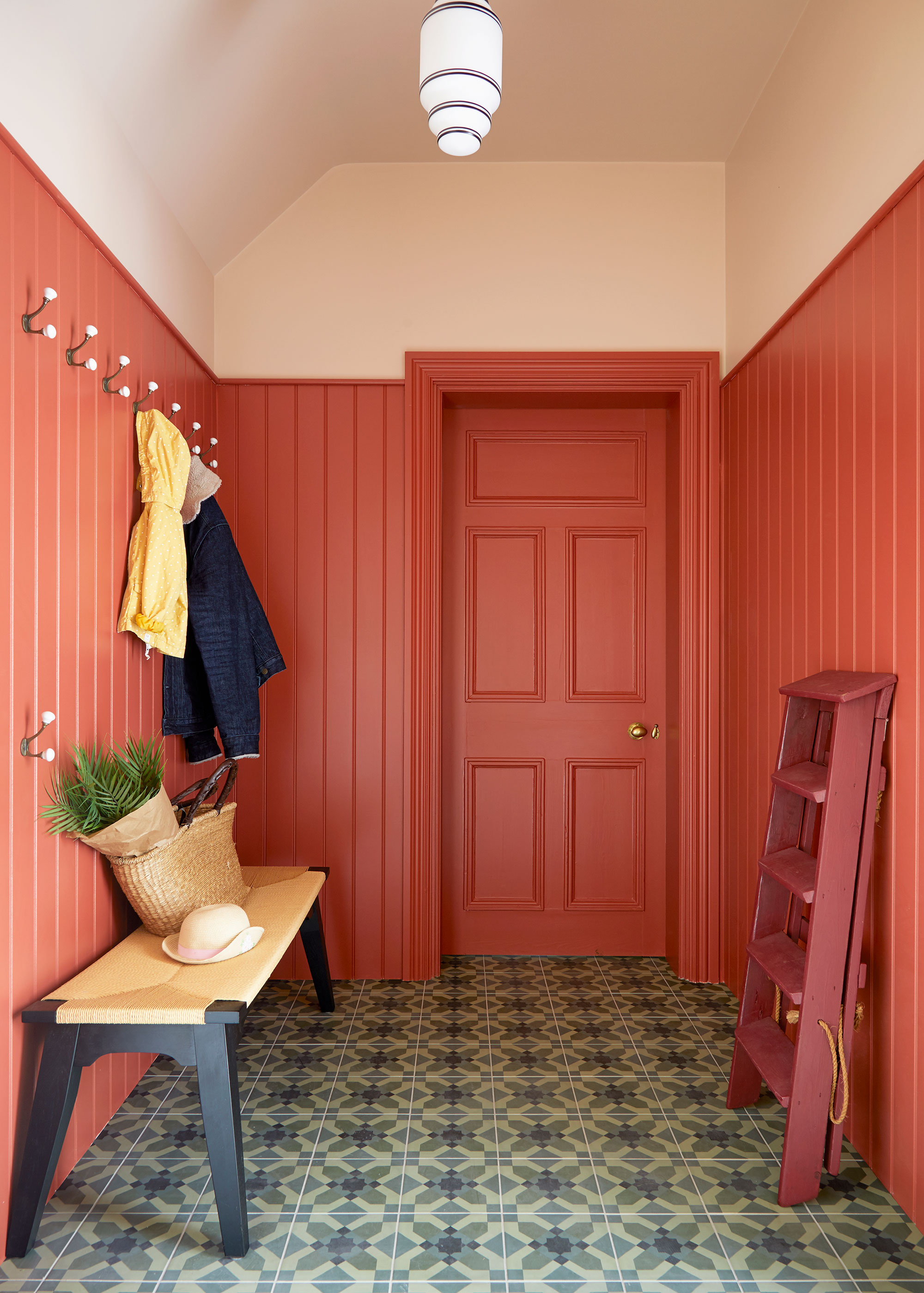 orange boot room with wall panelling and patterned floor tiles