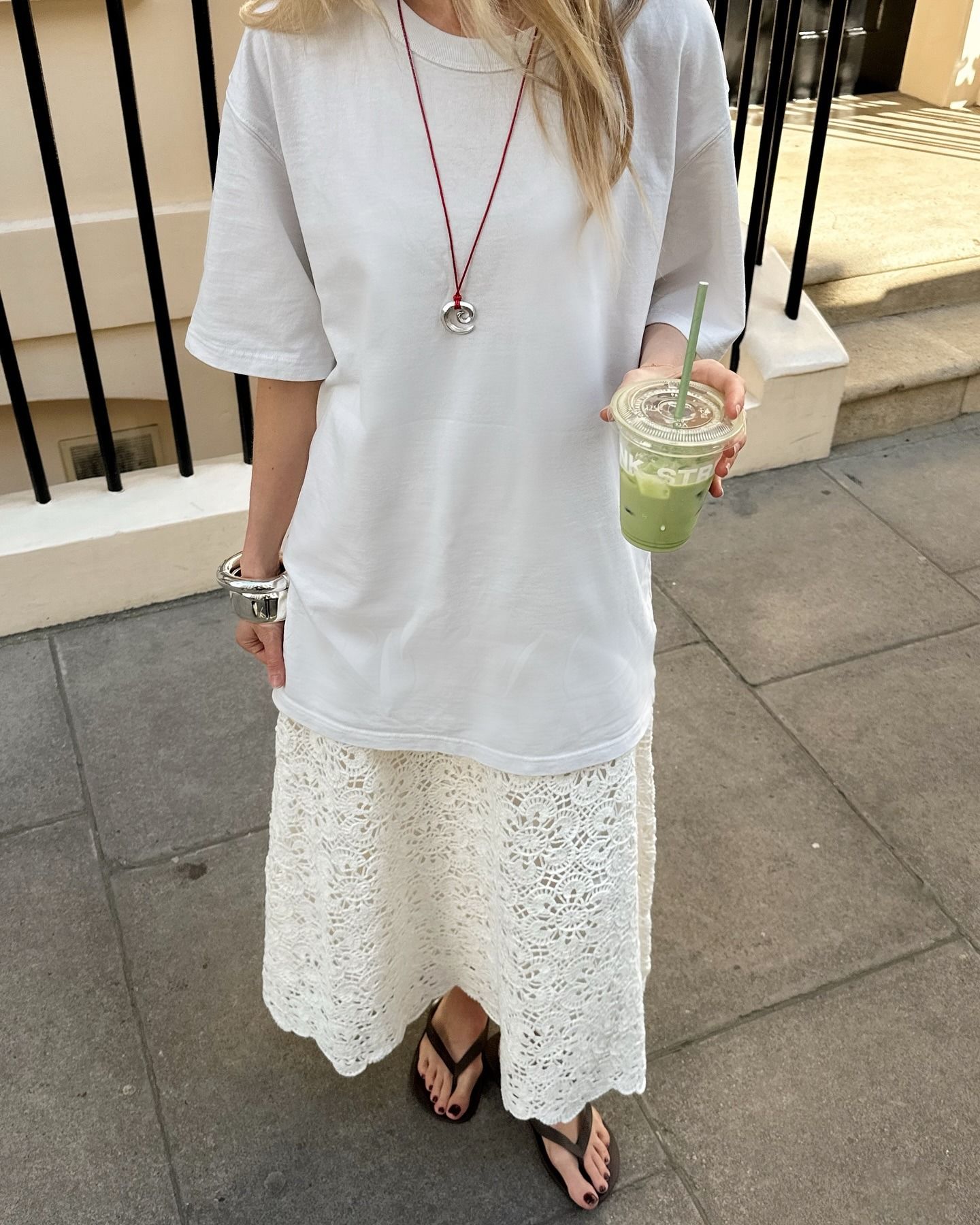 Woman wears White T-shirt, lace skirt and flip flops
