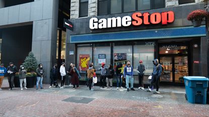 Photo of the front of a GameStop store showing a queue of shoppers