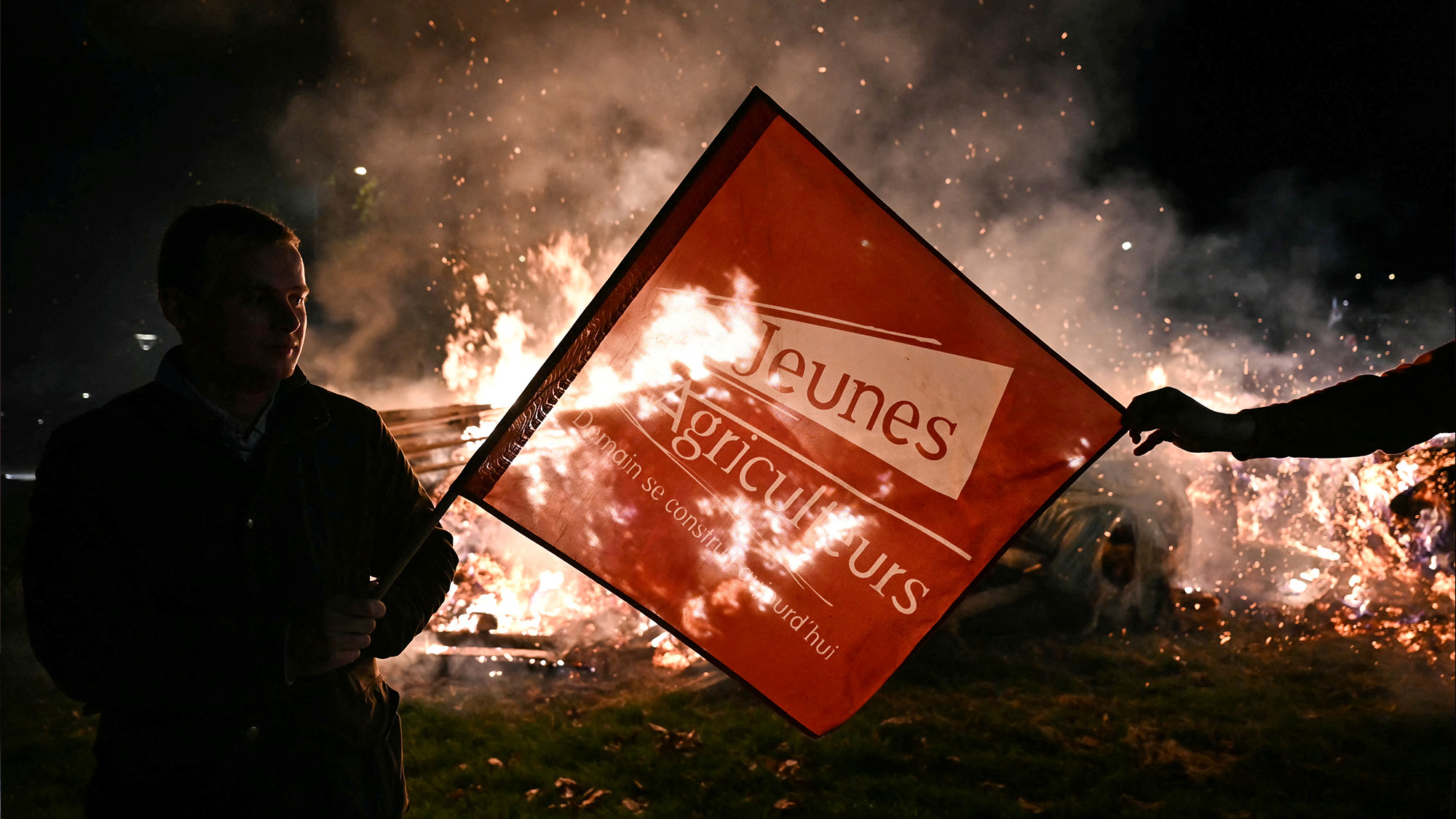 Protesters stand around a fire during a farmers demonstration in France