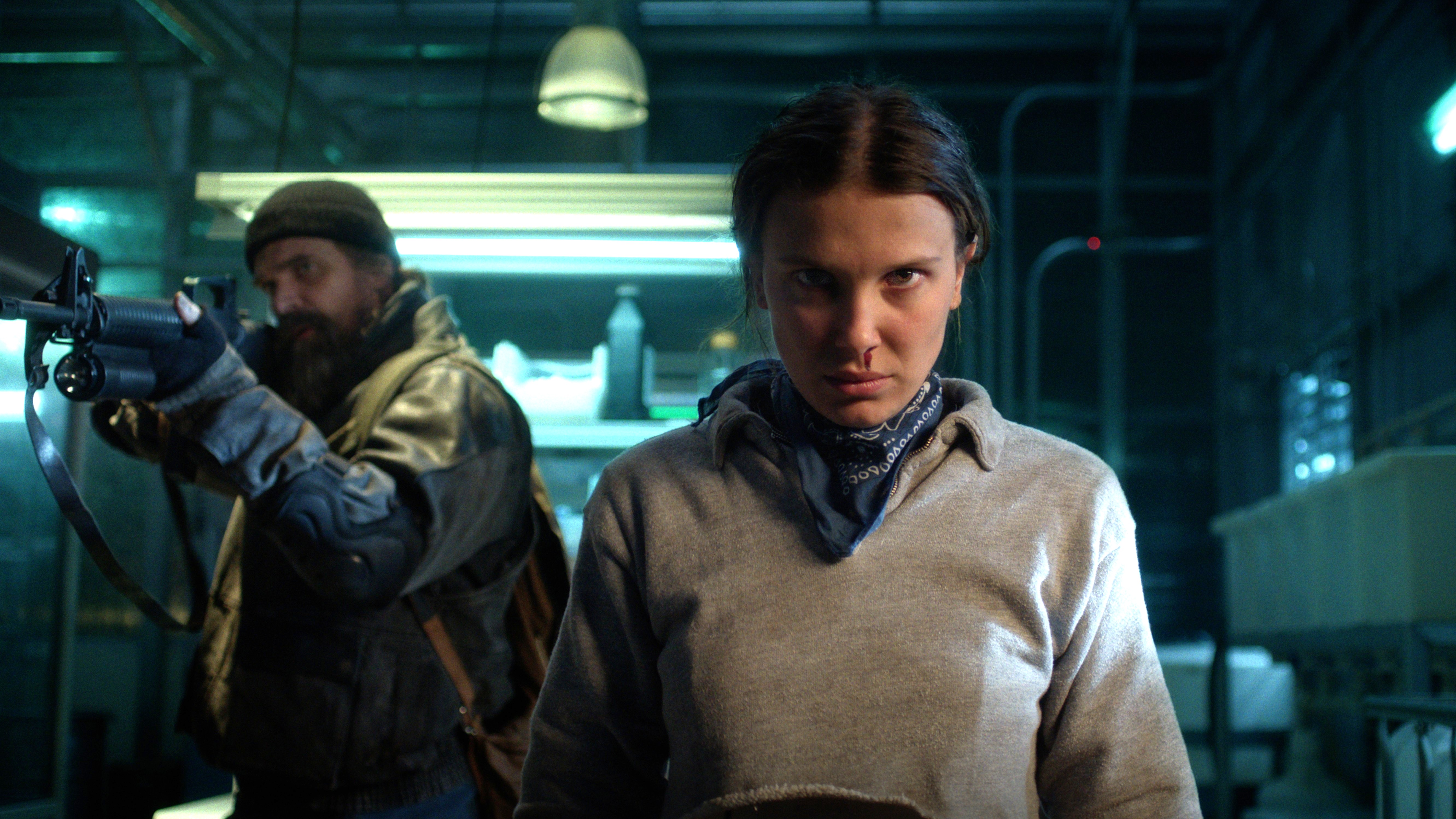 L-R: A shotgun-toting Jim (David Harbour) and Eleven (Millie Bobby Brown) in a scene from Netflix's "Stranger Things" season 5