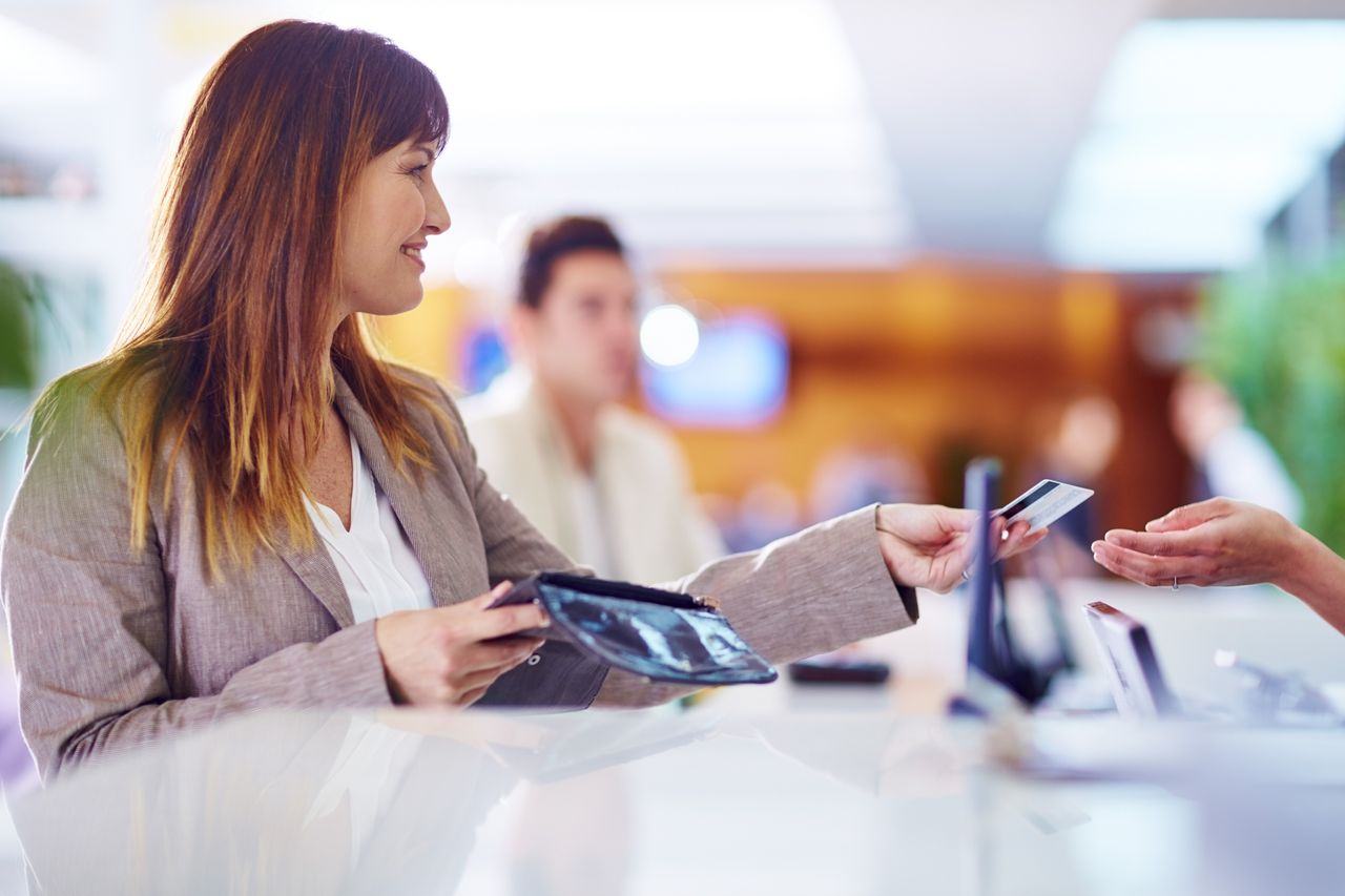 Businesswoman paying with credit card at hotel recption