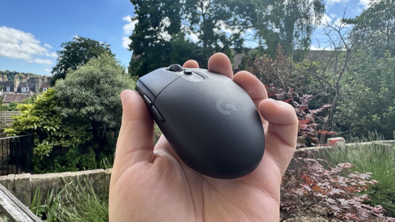 Logitech G305 X Superlight gaming mouse, held in a hand outside