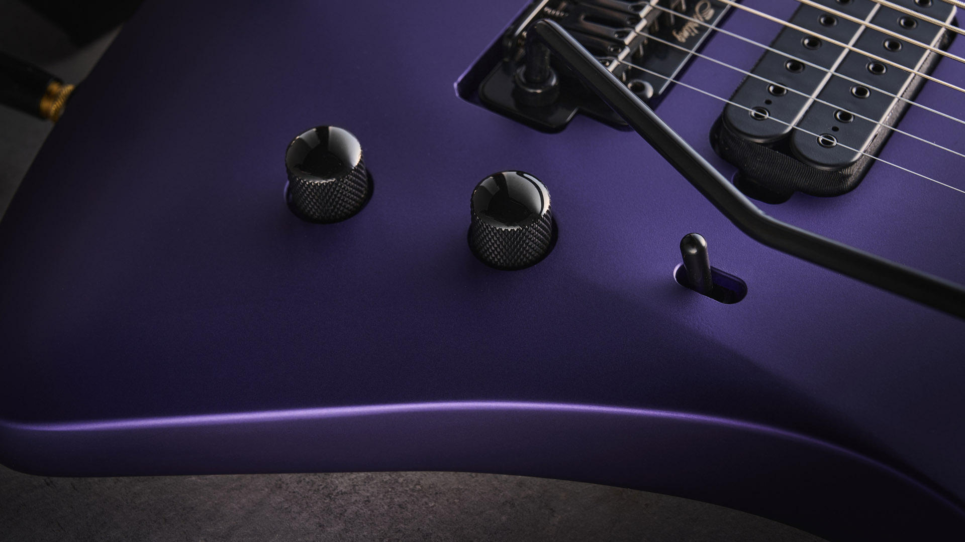 Sterling By Music Man Kaizen 7-string in Firemist Purple Satin, shot in close-up.