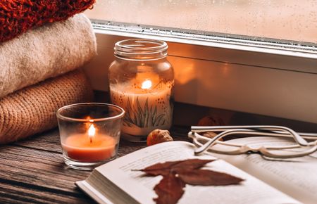 Close-Up Of Lit Candles On Table At Home