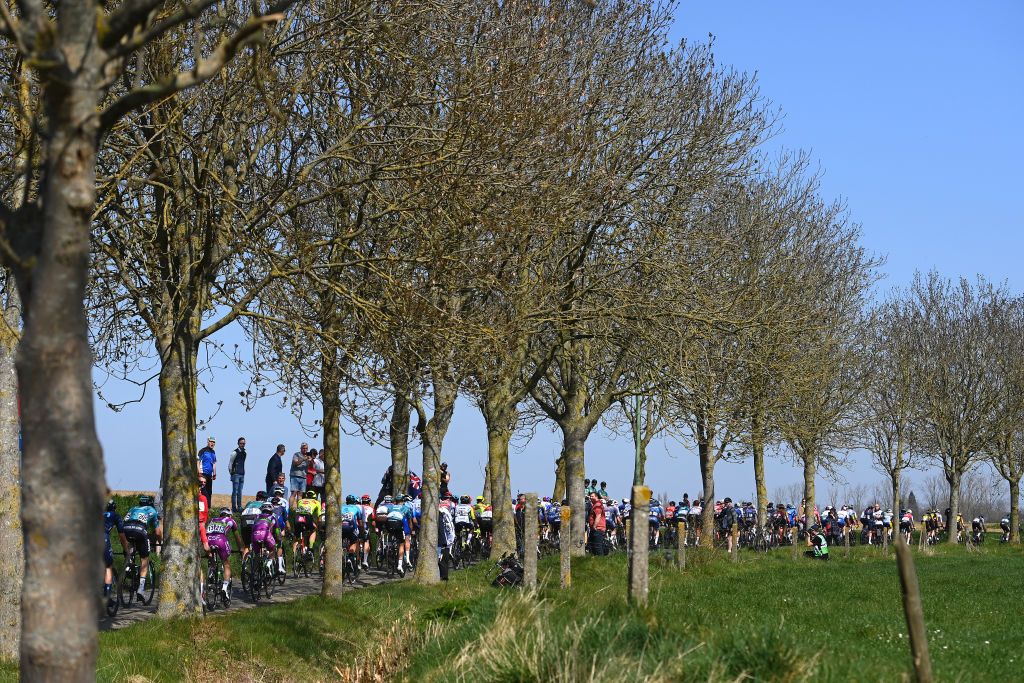 HARELBEKE BELGIUM MARCH 25 The peloton passing through a cobblestones sector while fans cheer during the 65th E3 Saxo Bank Classic 2022 a 2039km one day race from Harelbeke to Harelbeke E3SaxobankClassic WorldTour on March 25 2022 in Harelbeke Belgium Photo by Tim de WaeleGetty Images