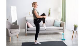 Woman standing on one leg holding the other one out in front of her, performing the ageing test