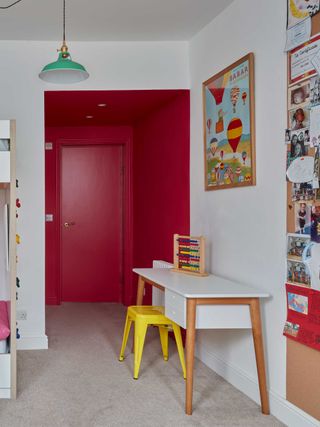 a kids room with a red painted entryway corridor