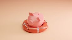 Piggy bank in a life preserver on a champagne colored background