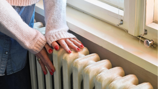 woman touching radiator