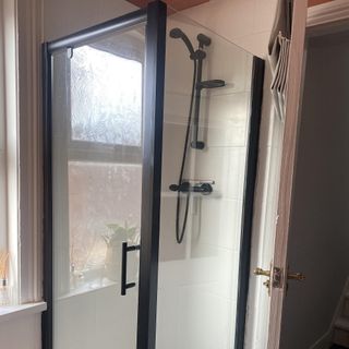 bathroom with shower cubicle and black shower head