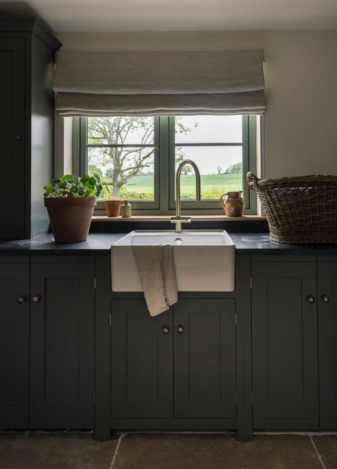 picture of dark utility area in home with naby cabinets and gold handles