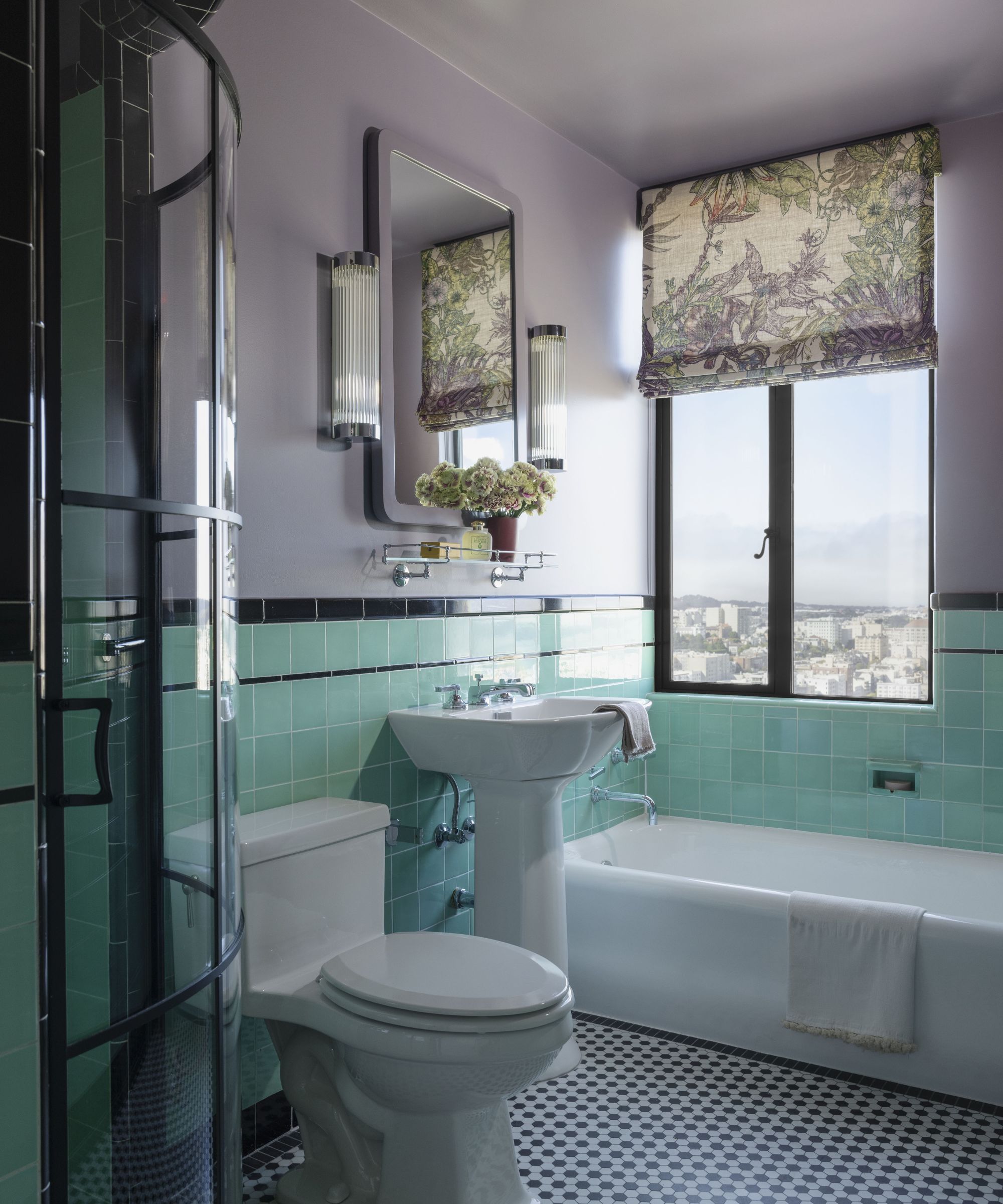 Small bathroom with half tiles walls in pale green and rest of the walls in pale purple