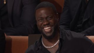 Kevin Hart laughing at his seat during Netflix's Roast of Kevin Hart
