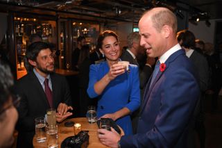 Catherine, Duchess of Cambridge offers a tub of dead larvae, used as livestock feed, to her husband Prince William, Duke of Cambridge, (R) while they speak with guests at a reception for the key members of the Sustainable Markets Initiative and the Winners and Finalists of the first Earthshot Prize Awards