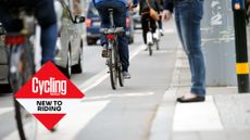 Image of cyclists in a bike lane going past crossing with pedestrian's legs