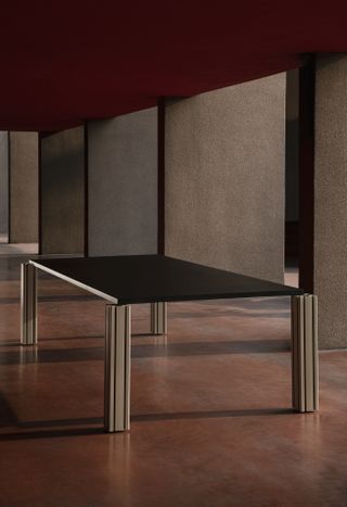 Metal legged table with a black top on a concrete floor