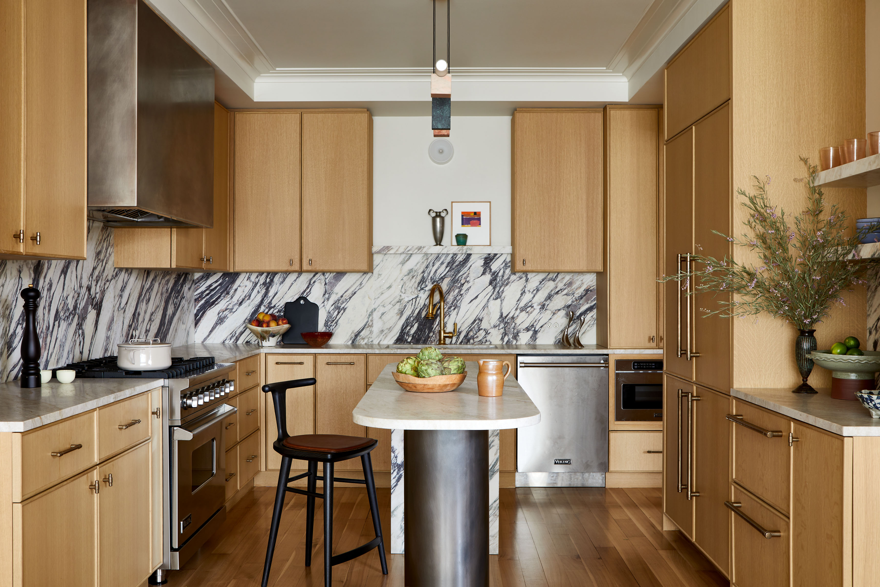wooden kitchen with veined marble backsplash and chrome details