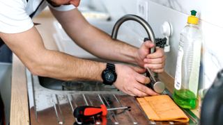 Man replacing kitchen sink mixer tap 