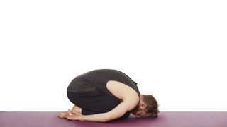 Yoga teacher Nick Higgins demonstrates child's pose