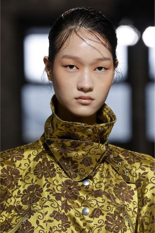 Model at Dries Van Noten wearing flyaways, a key Spring/Summer 2025 fashion month beauty look