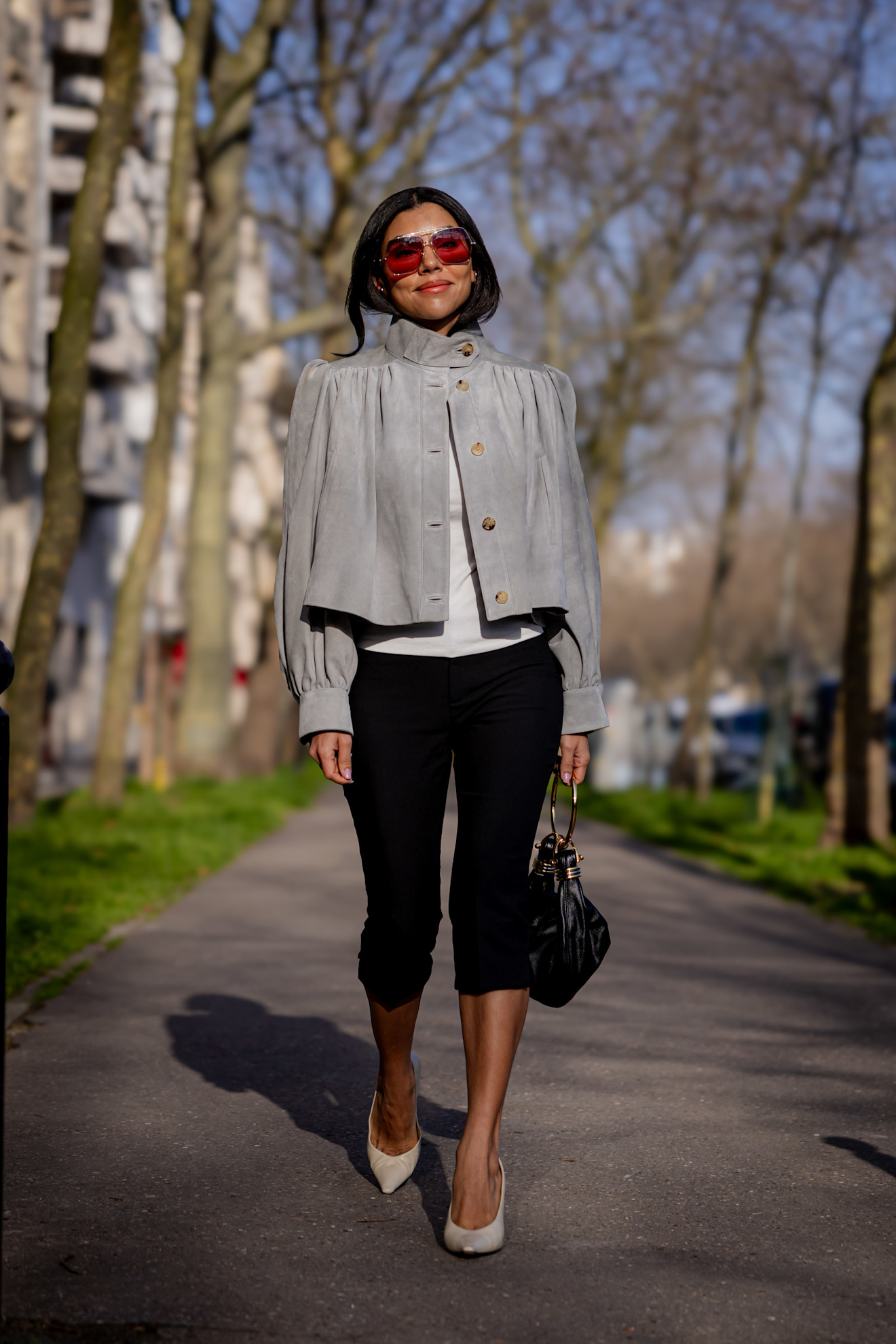 woman wearing cropped jacket, capris, and heels