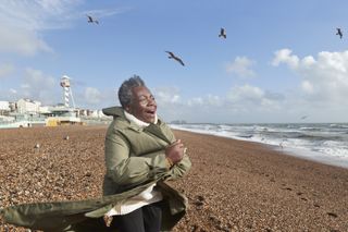 A woman looks happy on Brighton beach