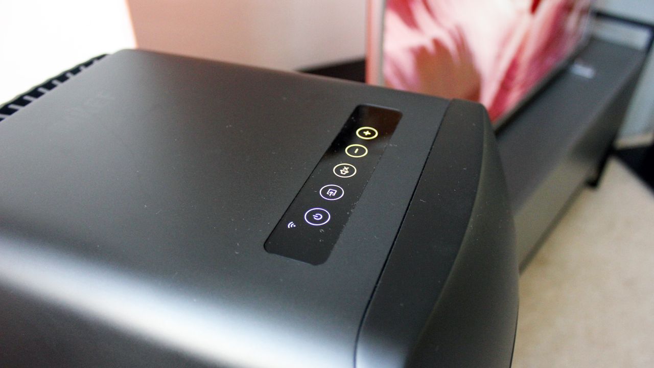 The top of a Kef LS50 speaker, showing platback controls on a glowing panel.