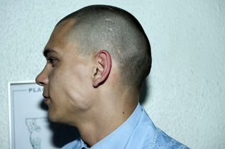 side profile of male model in blue shirt and shaved hair