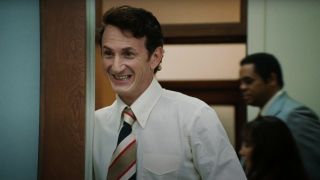Sean Penn stands smiling in a doorway in Milk.