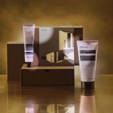 Image of Aesop skincare products on gold box and background.