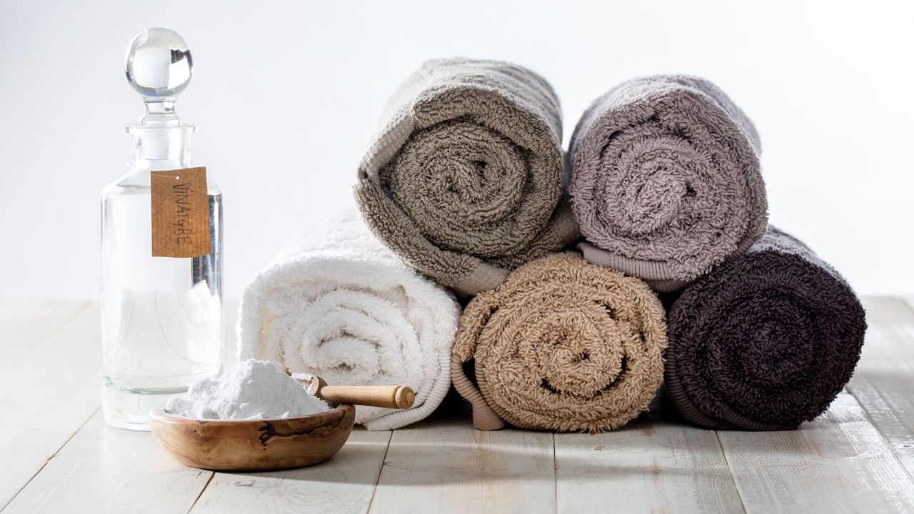 A container of baking soda beside a pile of towels