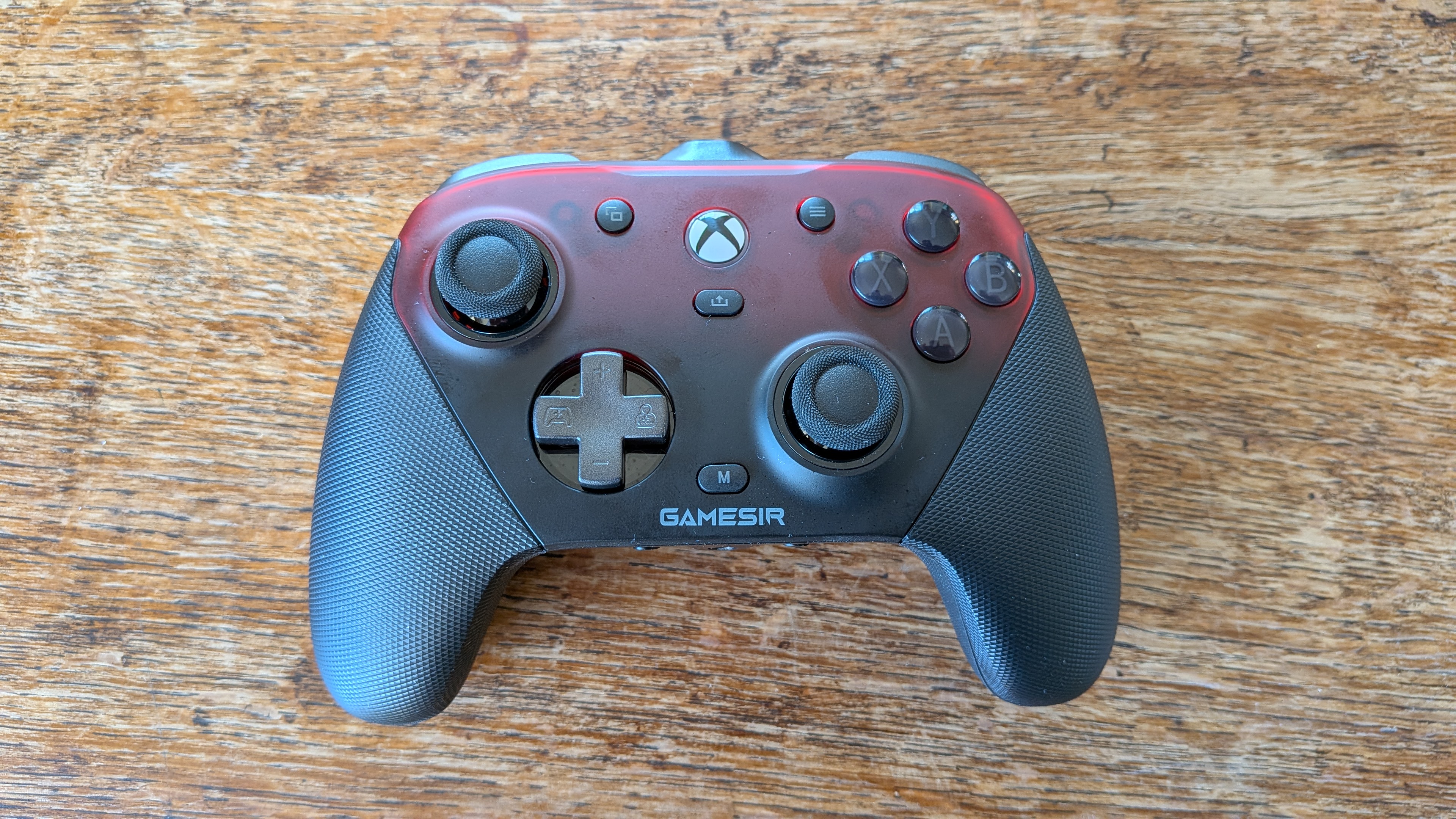 An image of the GameSir G7 Pro gamepad sitting on a wooden surface