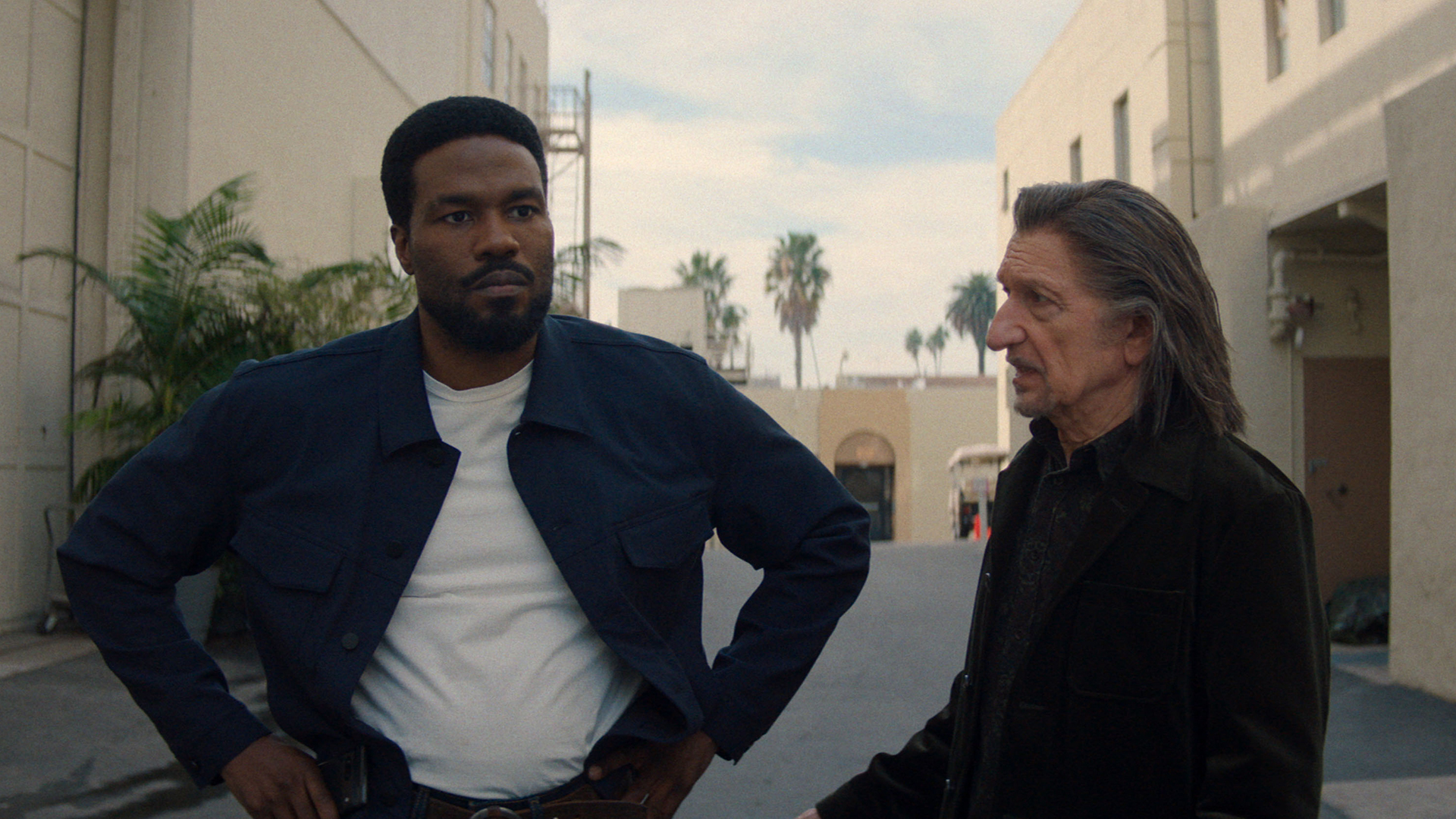 Simon Williams standing with his hands on his hips as Trevor Slattery looks at him in Marvel's Wonder Man