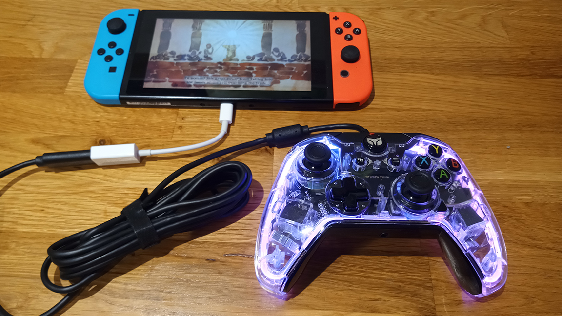 A photo of the BigBig Won Rainbow controller on a table with a Nintendo Switch