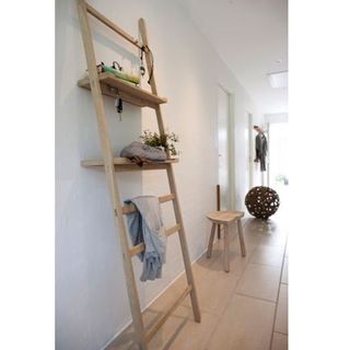 wooden ladder shelf at white wall hallway