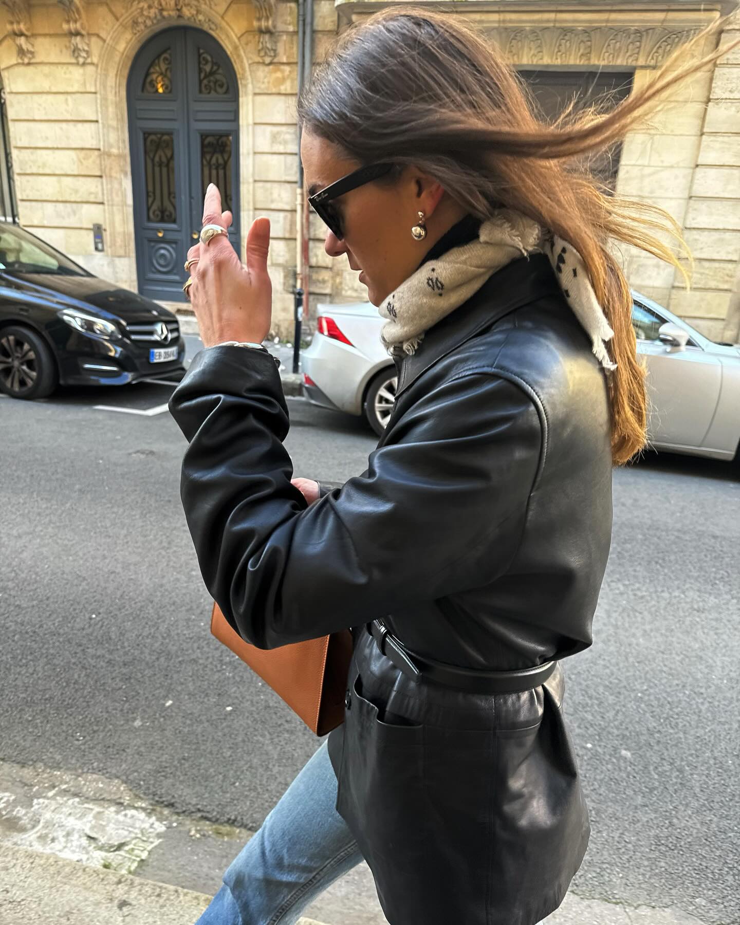 French girl wearing a leather jacket with jeans for spring with a Burberry bag