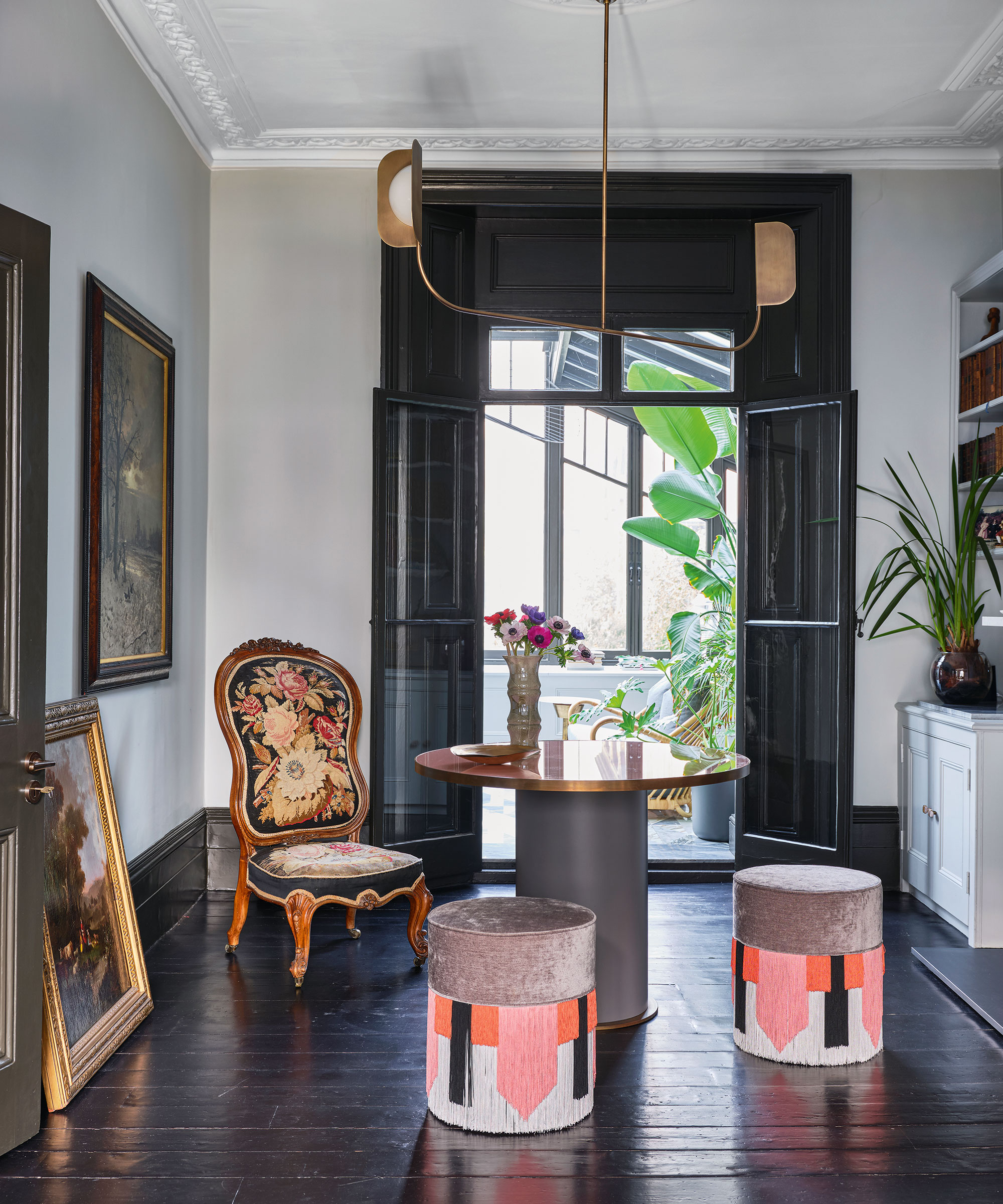 A black living room with white walls, colorful furniture, black floorboards, door and window frames.