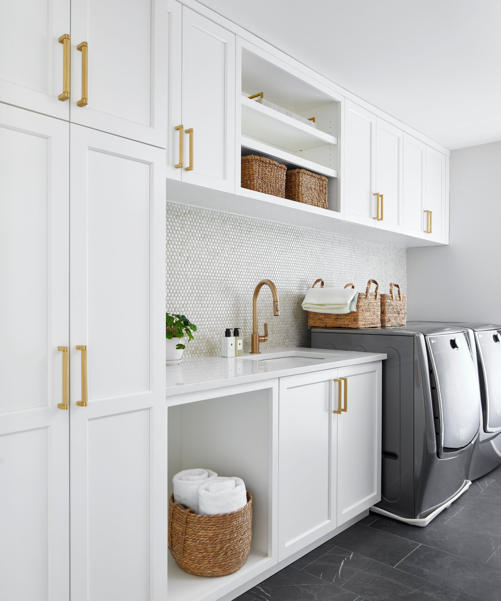White laundry room with cabinets and shelves