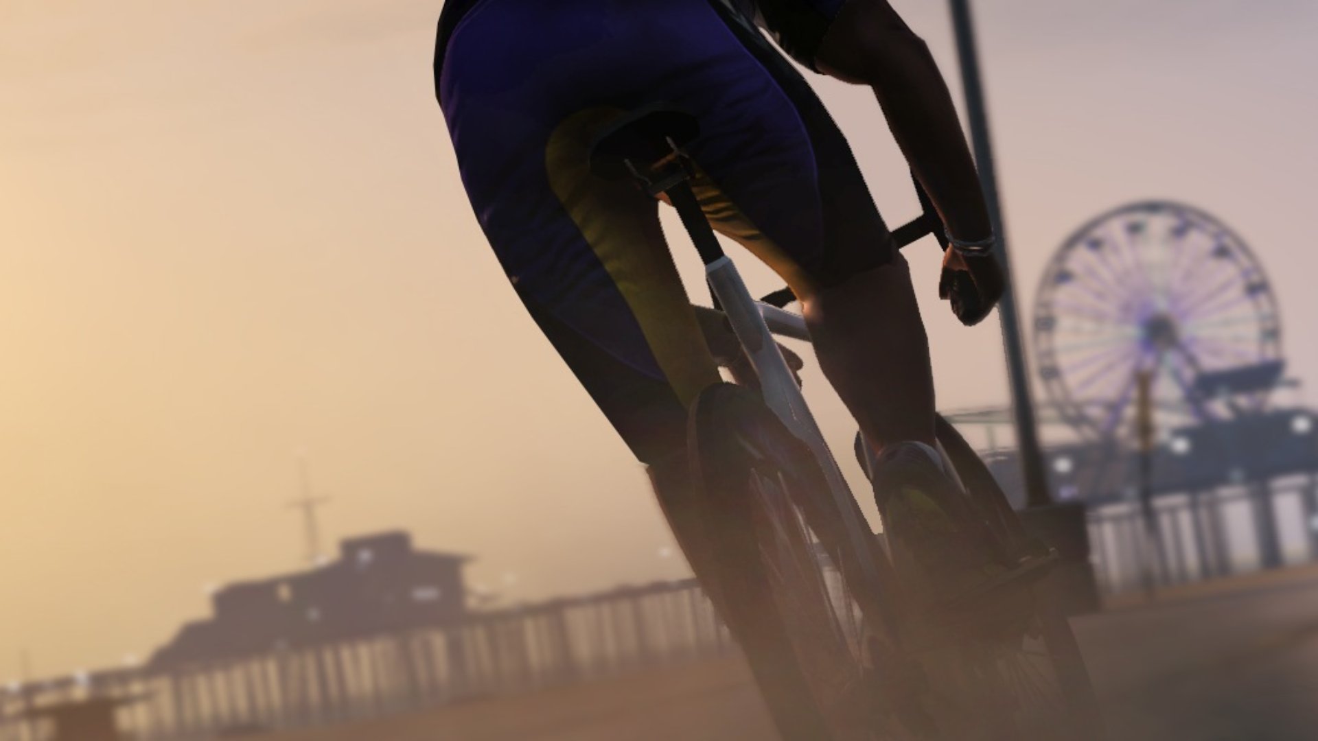 GTA 5 screenshot of a character riding a bike towards the pier, a Ferris Wheel and rollercoaster can be seen in the distance