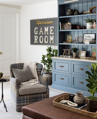 games room with blue storage cabinet, plaid chair and leather coffee table