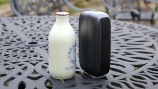 DWARFLAB Dwarf Mini next to a glass bottle of milk on a metal garden table