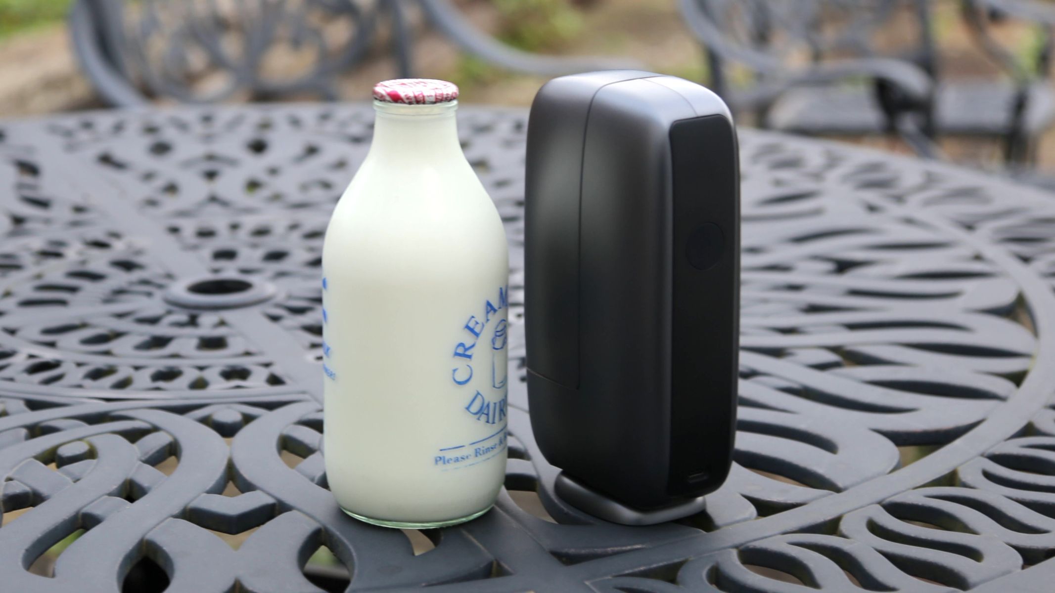 DWARFLAB Dwarf Mini next to a glass bottle of milk on a metal garden table