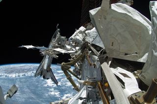 A digital camera with a fish-eye lens captured this image of NASA astronaut Michael Fincke (top center) during the fourth and last spacewalk of Endeavour's STS-134 mission as construction and maintenance continue on the International Space Station on May