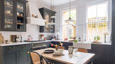Black Shaker-style kitchen with oak topped kitchen table and cane chairs