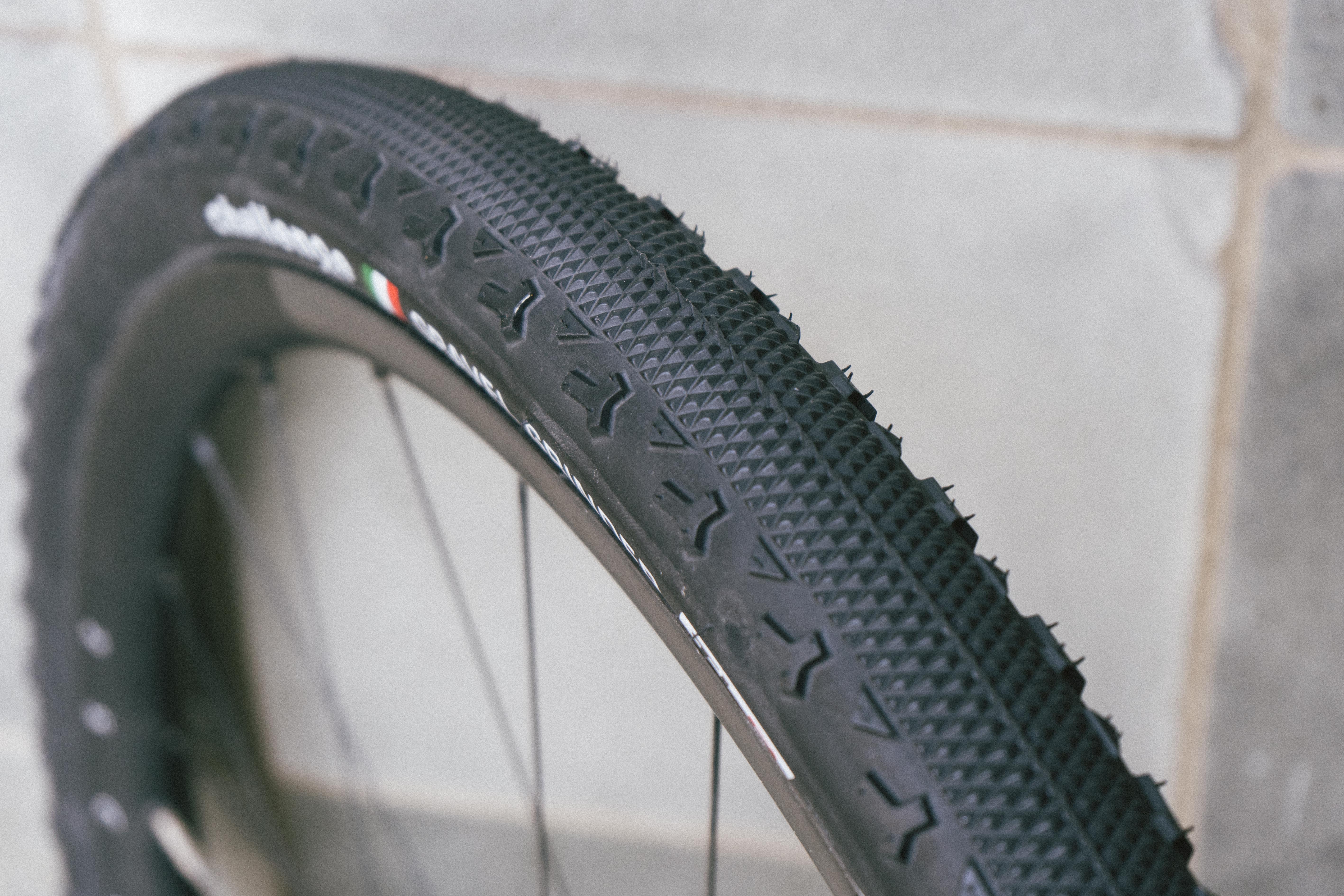 A black gravel tyre against a stone wall