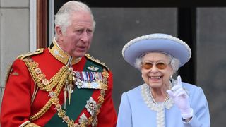 Queen Elizabeth stands with Prince Charles to watch a special flypast from Buckingham Palace